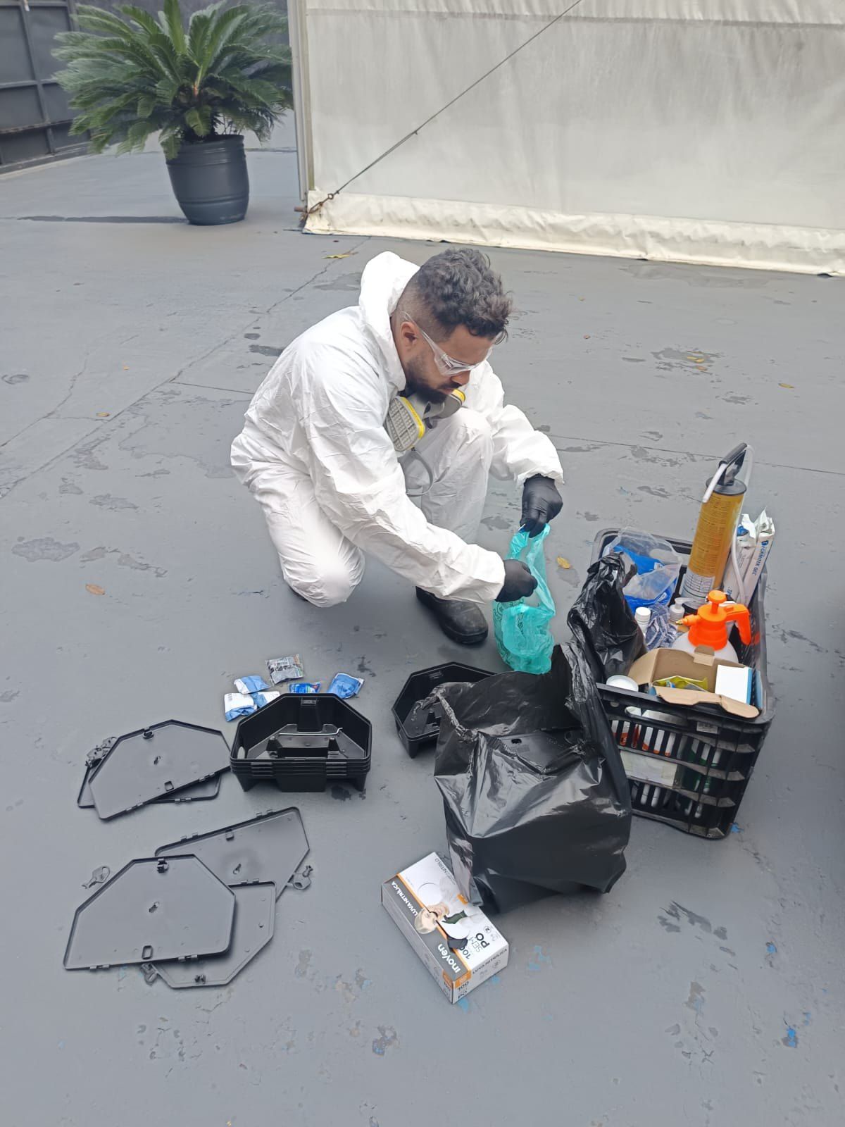Técnico da Elite Ambiental com equipamento de proteção separando produtos e porta-iscas